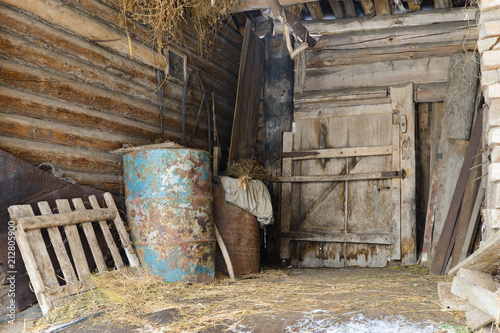 old abandoned barn with metal barrels and old things