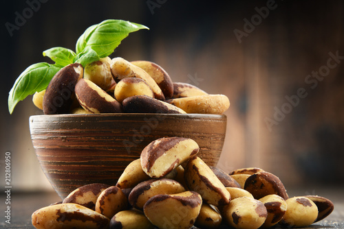 Bowl with Brazil nuts on wooden table