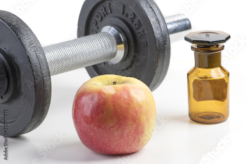 Sport dumbbell with Medezin bottle and apple