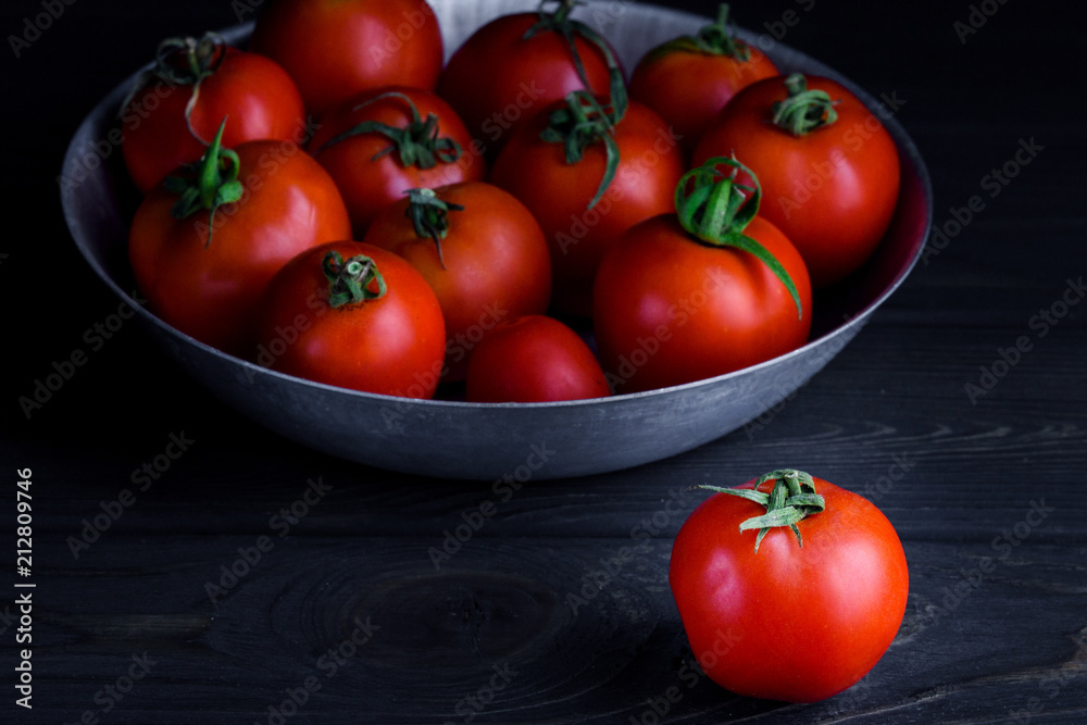 Ripe tomatoes on a dark table in a plate Ripe tomatoes on a dark table in a plate