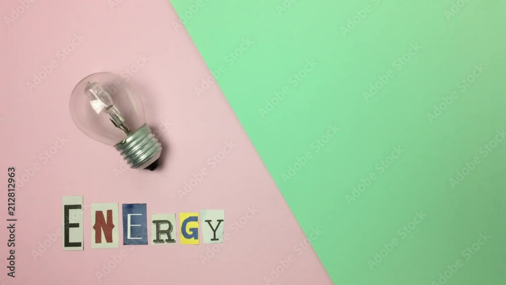 Bombilla moviendose junto a la palabra “energy” sobre fondo rosa y verde.