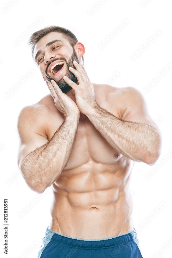 Fototapeta premium He stroked and touched his beard. A beautiful beard. Beautiful sporty guy male power. Fitness muscled in blue shorts. on isolated white background.