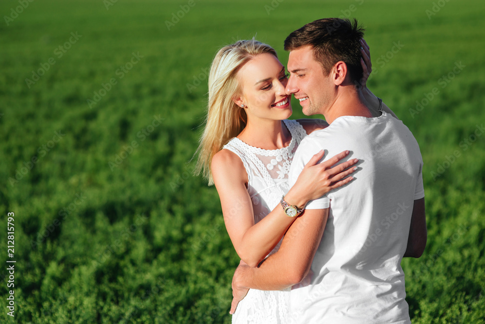 The lovely couple in love in a field.
