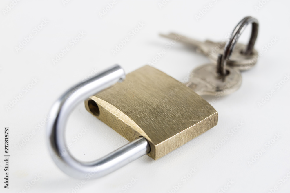 Brass padlock on a white table. Accessories for locking and securing against burglary. Brass padlock on a white table. Accessories for locking and securing against burglary.