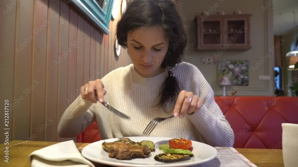 Woman enjoying the taste of grilled steak in restaurant Woman enjoying the taste of grilled steak in restaurant