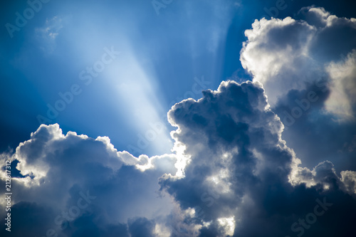 Fototapeta Naklejka Na Ścianę i Meble -  Abstract view of puffy summer thunderstorm clouds backlit by sun with rays streaming through.
