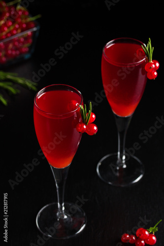 Two glasses redcurrant wine drink juice decorated with rosemary berries