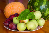 fresh sweet fruits on a plate on a wooden table