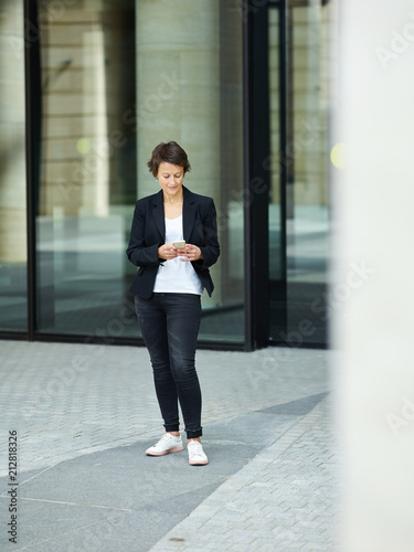 Businesswoman using phone on street