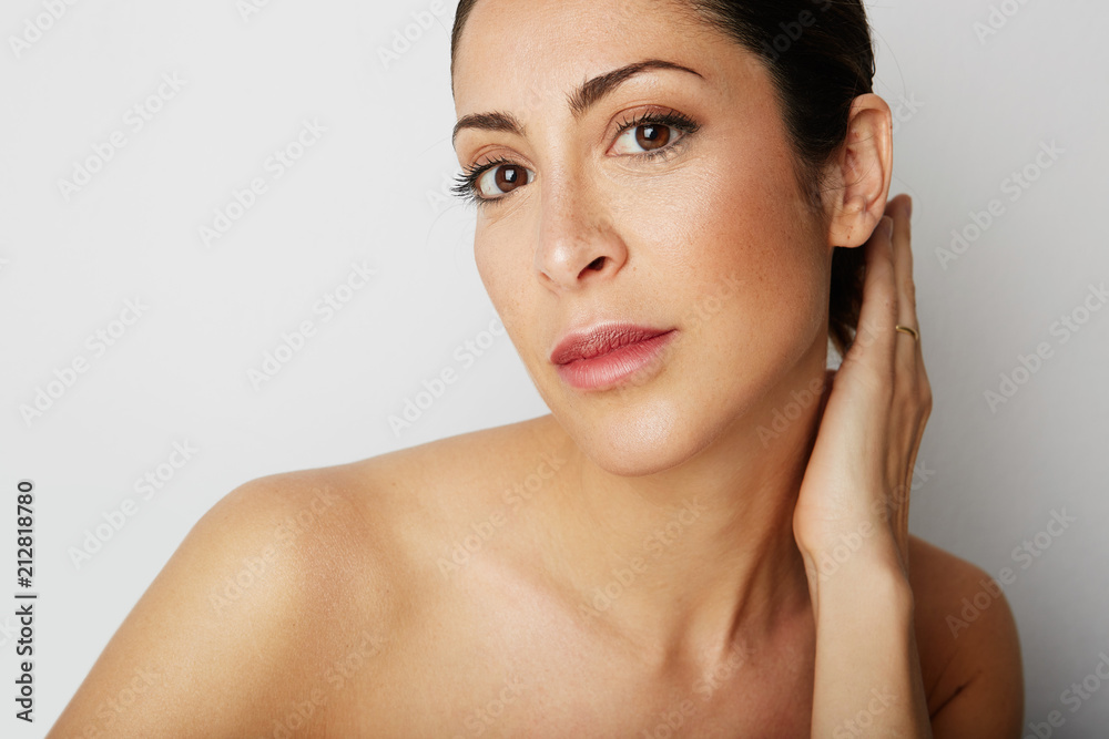 Portrait of handsome beauty woman with big brown eyes and dark eyebrows looking away over empty white background.Model with light nude make-up.Healthcare skin concept
