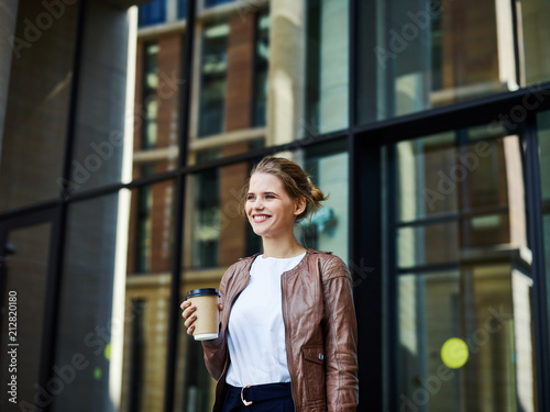 Smiling young businesswoman holding cup of coffee