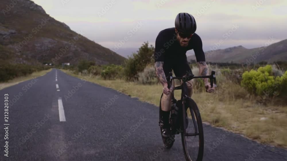 Wide angle shot of a male cyclist climbing up a mountain road. Man cycling on steep road on a hill.
Wide angle shot of a male cyclist climbing up a mountain road. Man cycling on steep road on a hill.