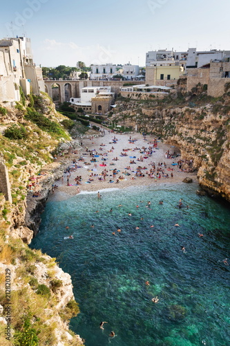 People swimming on lovely beach Lama Monachile in Polignano a Mare, Adriatic Sea, Apulia, Bari province, Italy, Europe photo