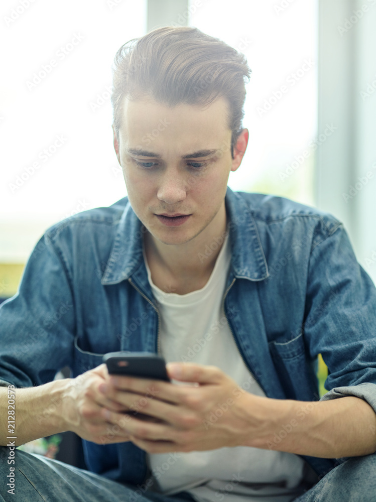 iligent man sitting with smartphone in hands iligent man sitting with smartphone in hands