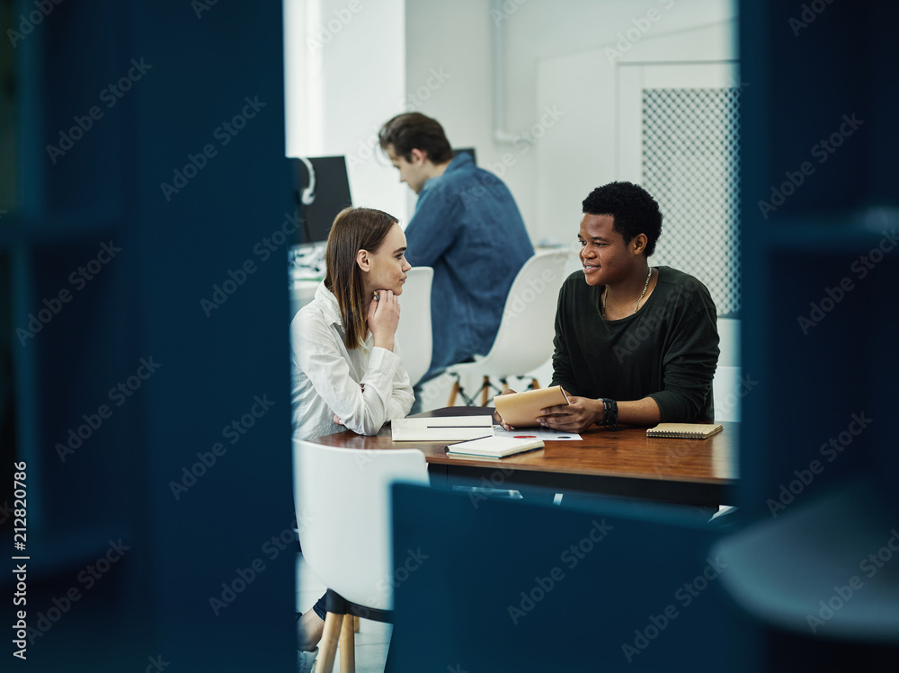 Multiracial couple communicating in library Multiracial couple communicating in library