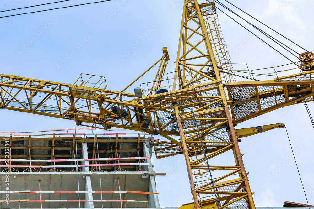 Construction site with cranes and building with blue sky