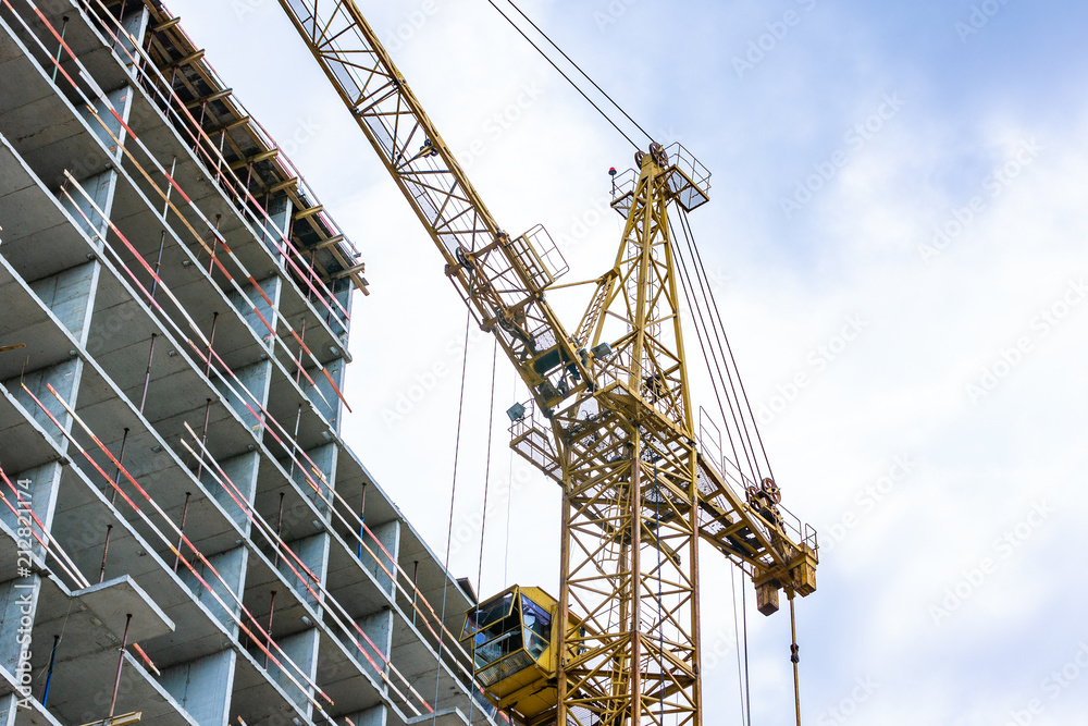 Construction site with cranes and building with blue sky