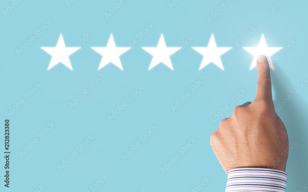 Hand choosing 5 stars rating on blue background - Positive feedback Hand choosing 5 stars rating on blue background - Positive feedback