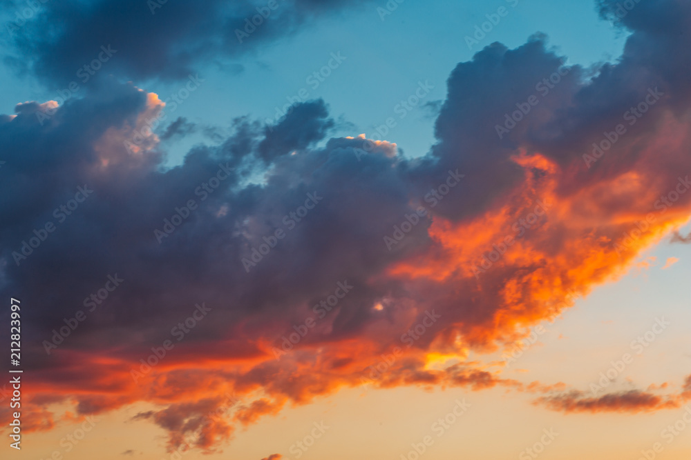 Colorful red and orange fluffy clouds at blue sky in sunset time, beautiful nature cloudscape