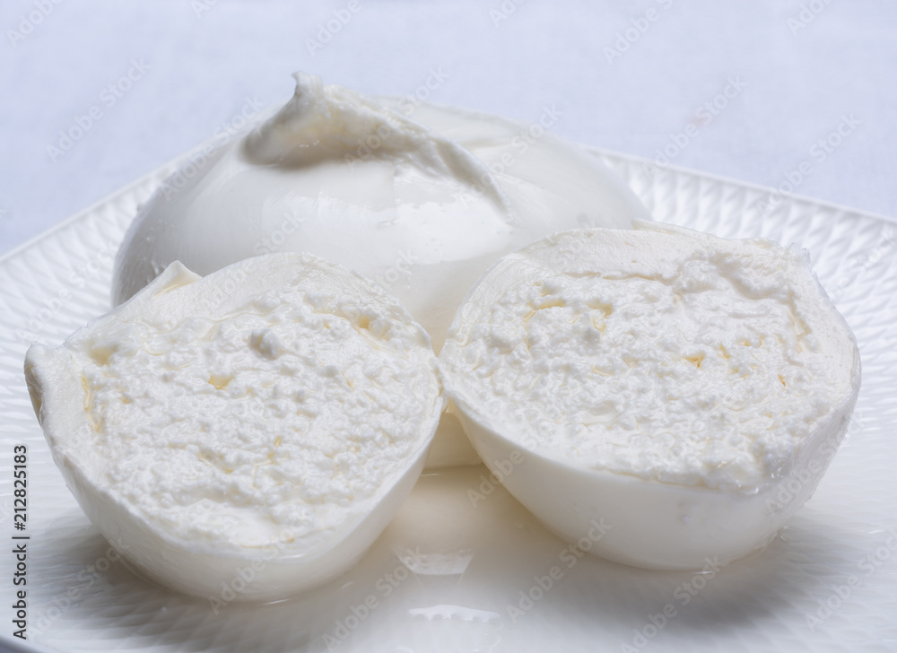 Fresh soft white burrata, ball buttery cheese, made from a mix of mozzarella and ricotta cream, original from Apulia region, Italy, very popular soft cheese in USA Fresh soft white burrata, ball buttery cheese, made from a mix of mozzarella and ricotta cream, original from Apulia region, Italy, very popular soft cheese in USA