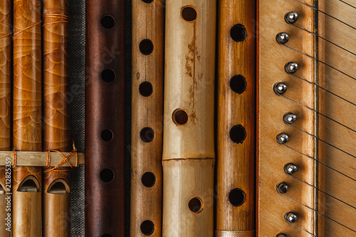 Pan flute and simple wooden flutes next to the psaltery, close-up