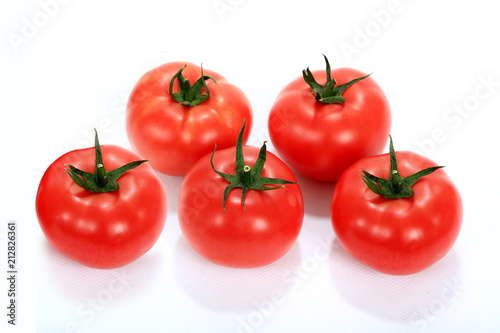 Pomidor czerwony, malinowy z szypółkami na białym tle.