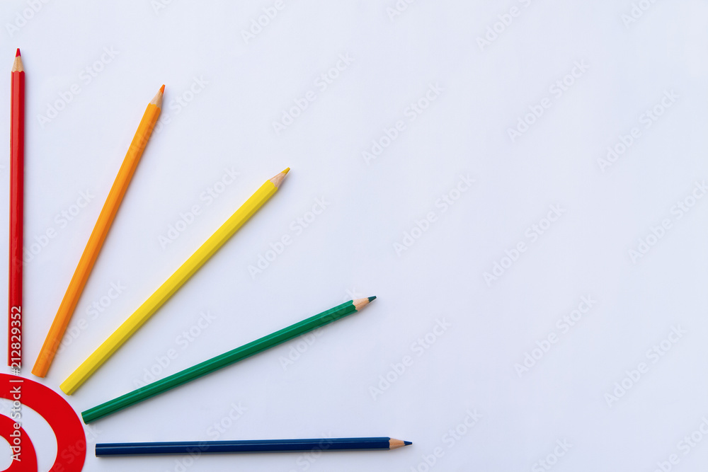 red curve and five color pencils on a white paper, copyspace red curve and five color pencils on a white paper, copyspace