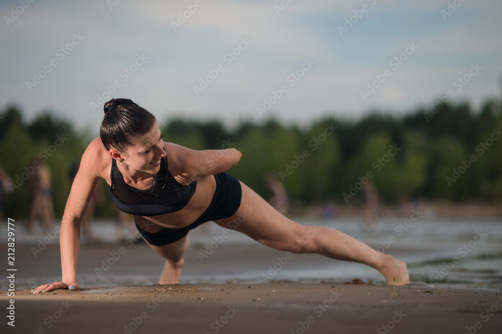 Cute woman doing push-ups on the beach against the sea Cute woman doing push-ups on the beach against the sea