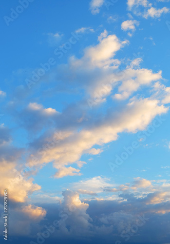 A blue sky with cumulus clouds at sunset ..