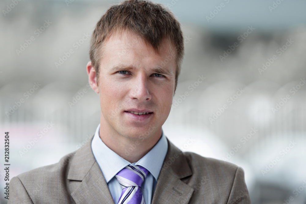 Young happy successful businessman in a gray suit