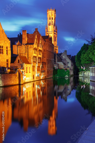 Scenic cityscape with a medieval fairytale town and tower Belfort from the quay Rosary, Rozenhoedkaai, at night in Bruges, Belgium