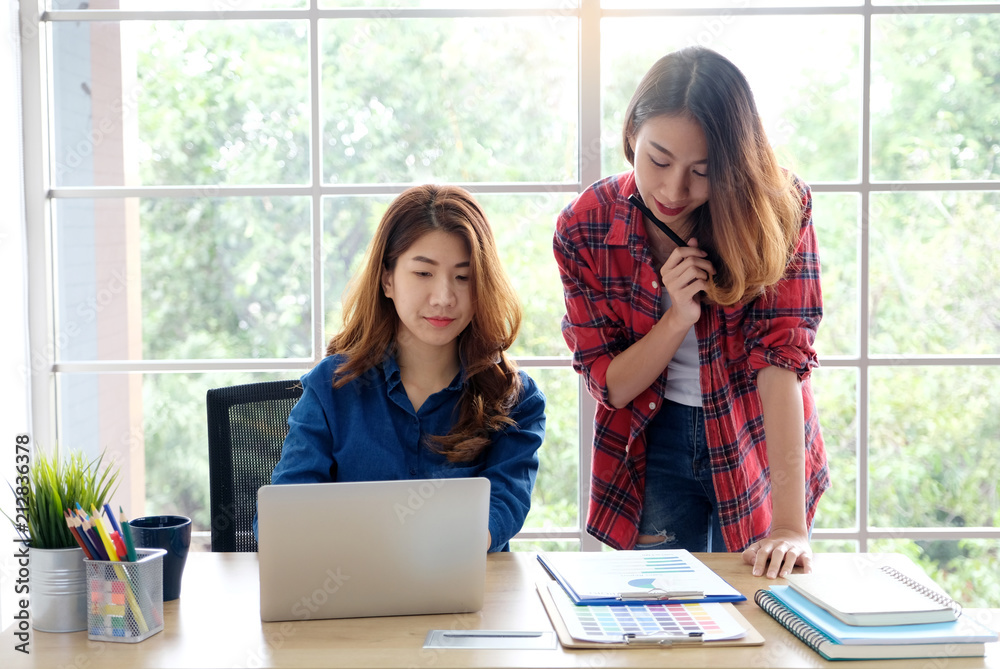 Two young asian women working with laptop computer at home office with happy emotion, working from home, small business, office casual lifestyle concept Two young asian women working with laptop computer at home office with happy emotion, working from home, small business, office casual lifestyle concept