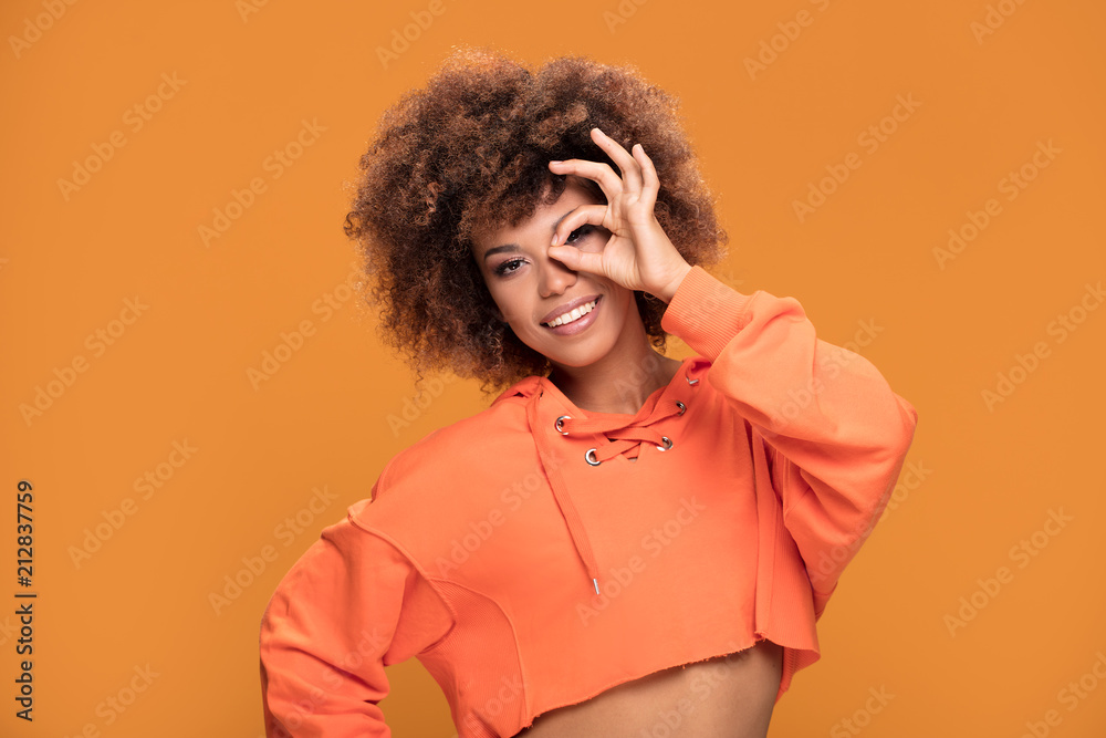 Smiling afro girl showing okay symbol.