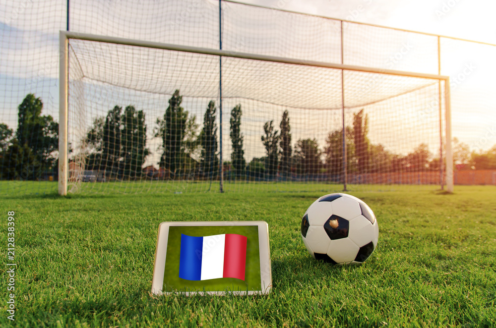 Φωτογραφία Soccer ball in front of empty goal and flag of France on digital tablet on the g