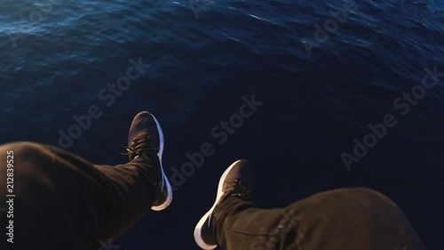 A teenager sitting above the sea. photo