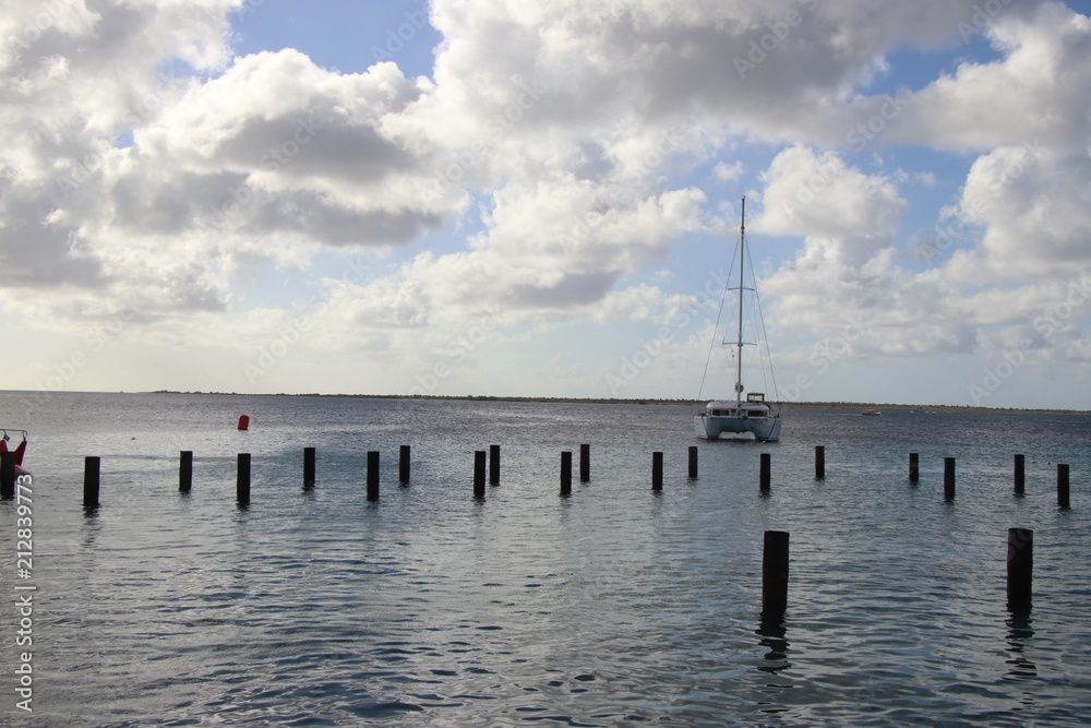 Sailboats on the ocean with pilings