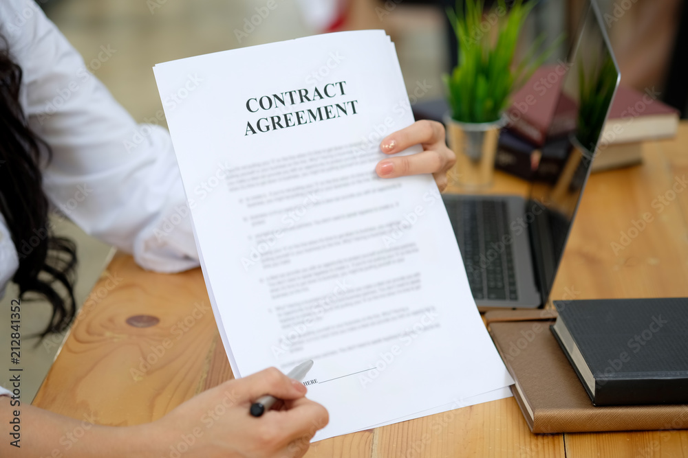 Businesswoman pointing sign terms and conditions document paper in board room. Businesswoman pointing sign terms and conditions document paper in board room.