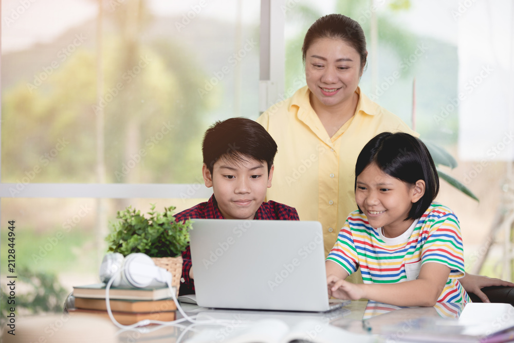 Asian teacher and kids entertaining using laptop computer. Asian teacher and kids entertaining using laptop computer.