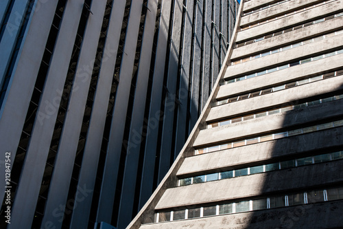 Rounded corporate concrete building detail view with shadows on the walls