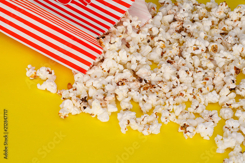 Popcorn in a cardboard box on a yellow background.