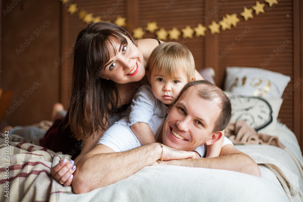 Family in bed playing and smiling Family in bed playing and smiling