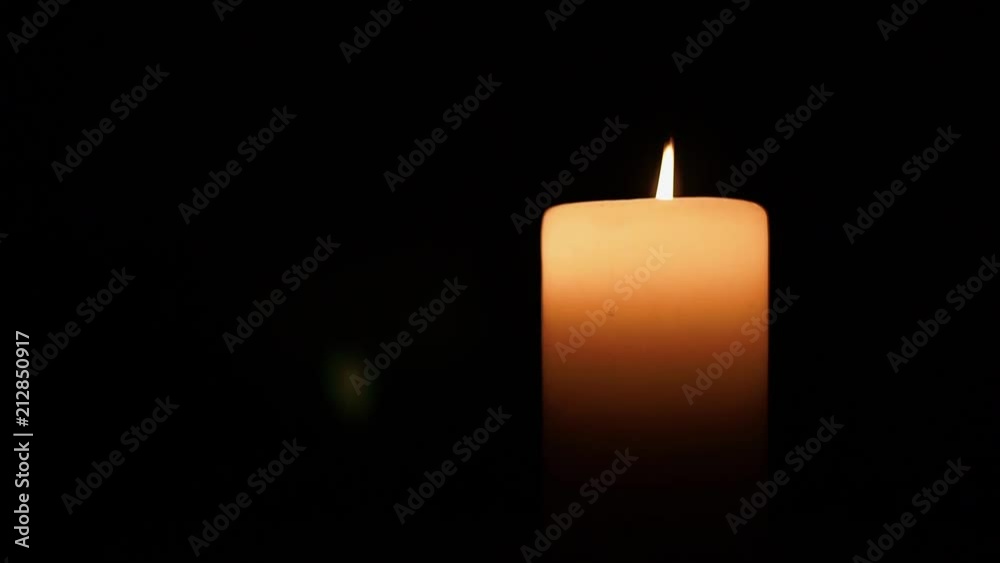 A single candle flickering in the darkness A single candle flickering in the darkness