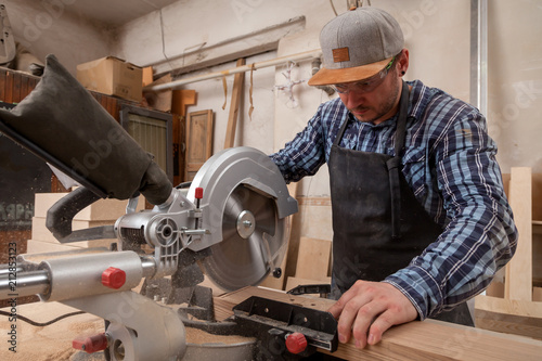 carpenter work with circular saw for cutting boards, the man sawed bars, construction and home renovation, repair and construction tool