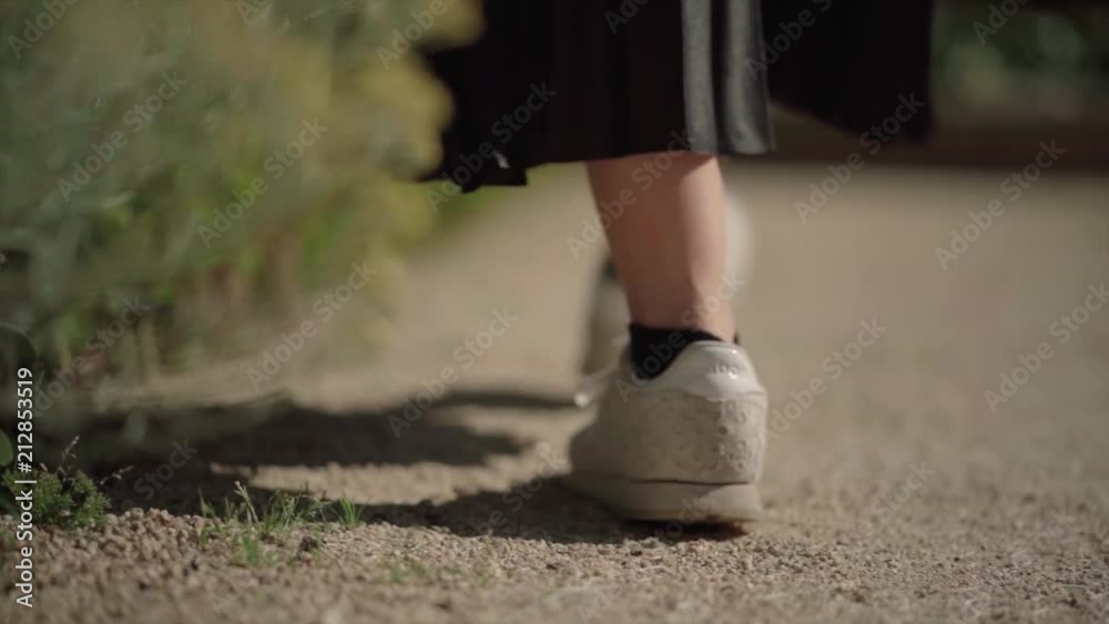 Girl Walks in the park, steps on gravel. Slow Motion. Girl Walks in the park, steps on gravel. Slow Motion.