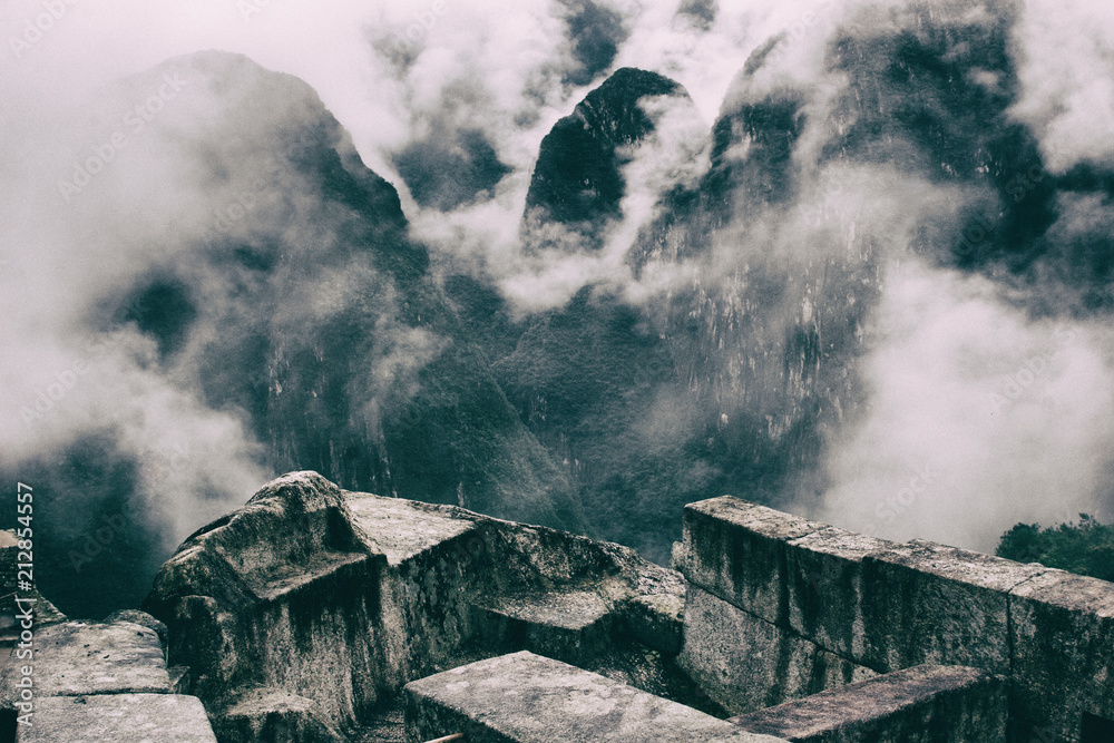 Fototapeta premium Beautiful image of Machu Picchu ruins and the clouds over the mountains on the background. Prize for hiking the Inca Trail. Peru. South America. No people.