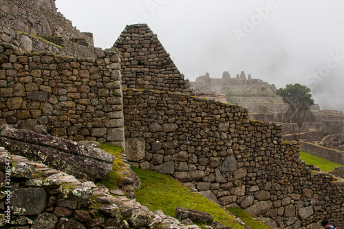 Machu Picchu stone ruins with low clouds and the nature on the background. Peru. South America. No people.