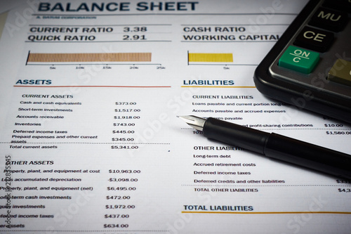 balance sheets with calculator and pen
