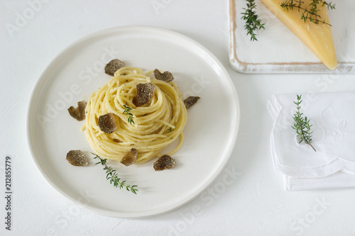 Obraz na płótnie Pasta with creamy cheese sauce and truffle on a light plate, served with cheese and wine. w salonie
