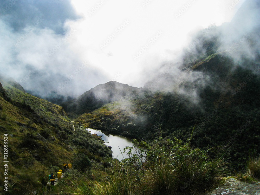 Fototapeta premium Serene lake water in the wild jungle nature of the mountains with mist along the Inca Trail. Peru. South America. No people.