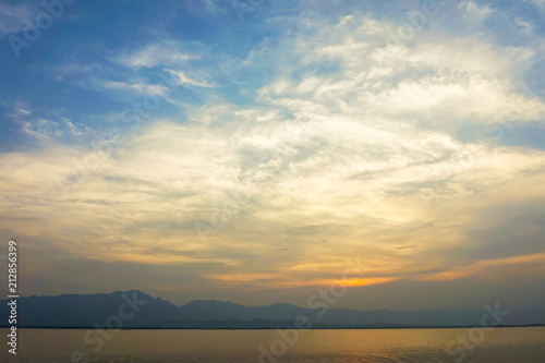 landscape of clouds sky sunset over lake with mountains